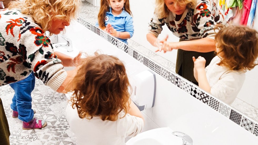kids and teacher wash their hands